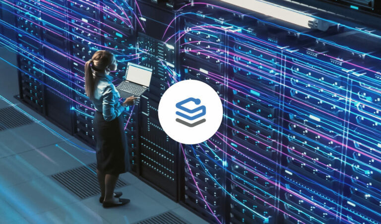 A woman in a blue shirt and black skirt uses a laptop while standing in front of a wall of servers, with colorful data cables illuminated in blue and pink. A logo is displayed in the center of the image.